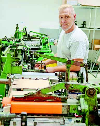 Weiß, wie alte Maschinen ticken: Produktionsmitarbeiter Sascha Knaf beim Herstellen von Papierbeuteln für Versandmuster.